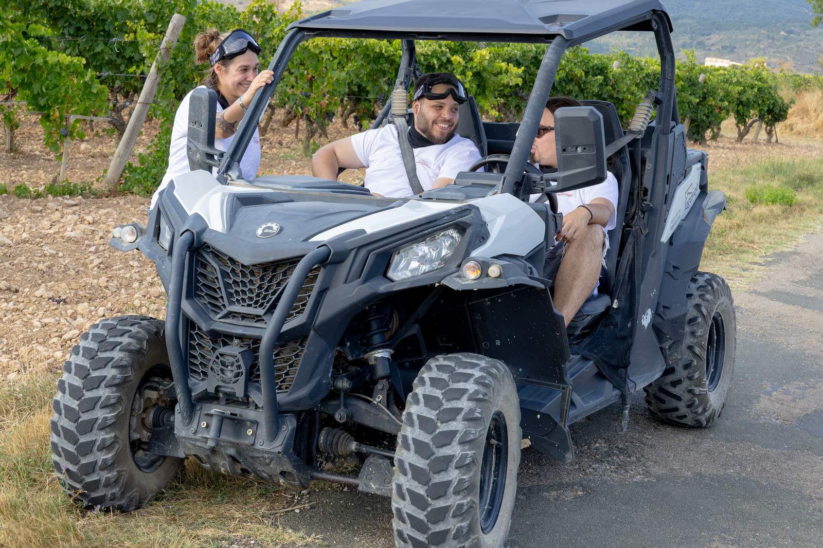 Grupo de amigos en un buggy por un camino entre viñedos de Rioja Alavesa
